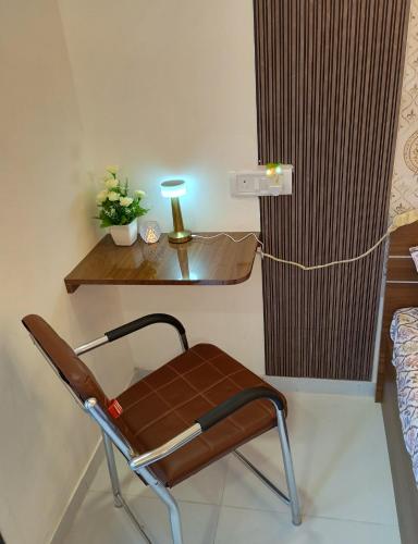a chair in a room with a desk and a lamp at Glorious Studio Hill view with pvt Balcony Karjat in Bhimashankar