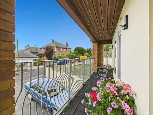 a balcony with a bed and flowers on it at Spacious 3-Bed Home in North Cornwall | Walk to Wadebridge | Near Camel Trail, Padstow & Rock | Free Parking in Wadebridge
