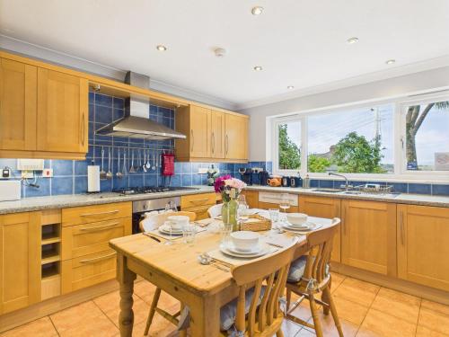 a kitchen with wooden cabinets and a wooden table at Spacious 3-Bed Home in North Cornwall | Walk to Wadebridge | Near Camel Trail, Padstow & Rock | Free Parking in Wadebridge