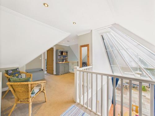 a white staircase with a chair in a room at Spacious 3-Bed Home in North Cornwall | Walk to Wadebridge | Near Camel Trail, Padstow & Rock | Free Parking in Wadebridge