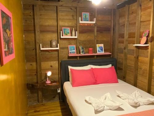a bedroom with a bed with red pillows and wooden walls at Peaceful Refuge in Quiete Bay in Bocas del Toro