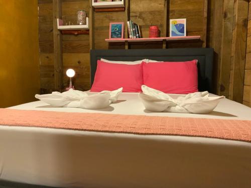 a bed with three white bowls on it with red pillows at Peaceful Refuge in Quiete Bay in Bocas del Toro