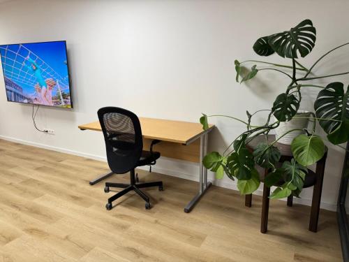 an office with a desk and a chair and a plant at Priestranny 3-izbovy apartman in Brenner