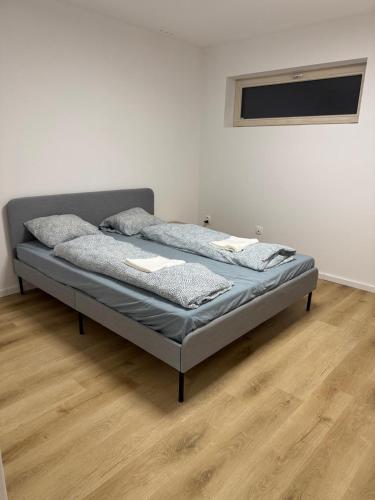 a bed in a room with a wooden floor at Priestranny 3-izbovy apartman in Brenner