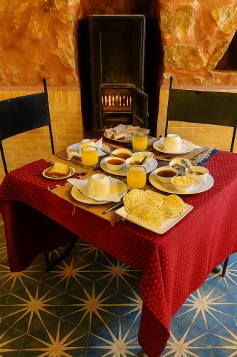 a table with a red table cloth and food on it at Auberge La Fibule Du Dades in Aït Idaïr