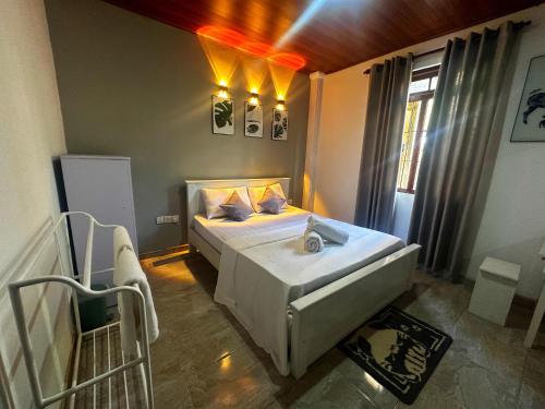 a bedroom with a large bed and a window at Hotel Halona in Kandy