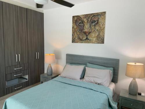 Un dormitorio con una cama y un cuadro de un león. en La Escondida 34, en Playa del Carmen