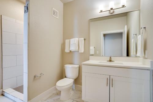 a bathroom with a toilet and a sink and a mirror at Pool Access, 1 Mi to Shops and Eats Crowley Rental in Crowley