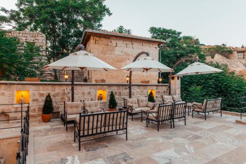 a patio with tables and chairs and umbrellas at Lagoon Cave Suites in Urgup