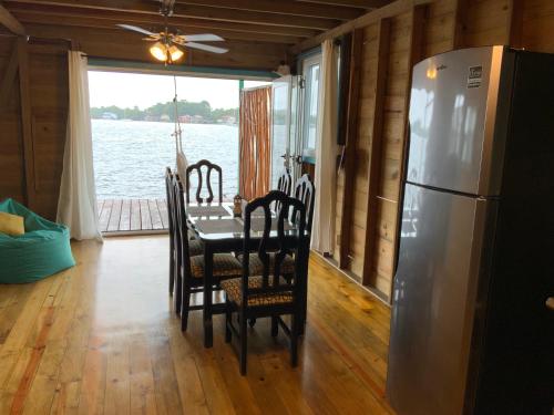 a dining room with a table and a refrigerator at Peaceful Refuge in Quiete Bay in Bocas del Toro