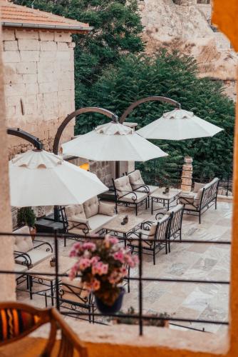 a group of tables and chairs with umbrellas at Lagoon Cave Suites in Urgup