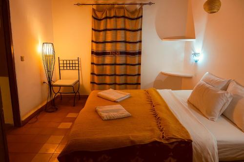 a bedroom with a bed with two towels on it at Auberge La Fibule Du Dades in Aït Idaïr