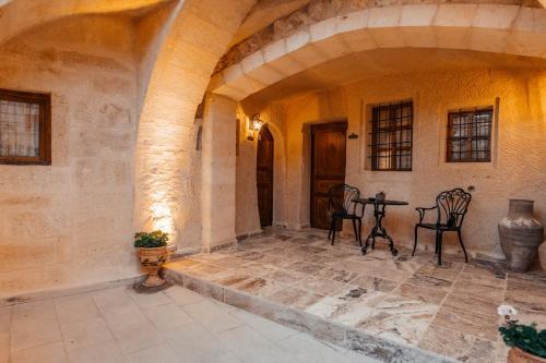 a patio with chairs and a table in a building at Lagoon Cave Suites in Urgup
