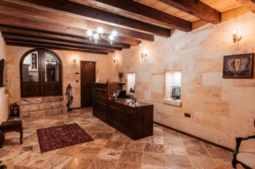 a large room with wooden ceilings and a stone wall at Lagoon Cave Suites in Urgup