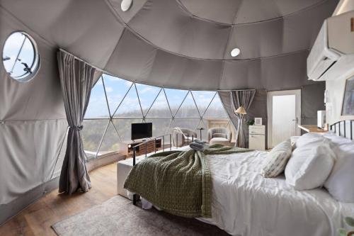 ein Schlafzimmer mit einem Bett und einem großen Fenster in der Unterkunft "Bluegrass Bluff" - The Overlook LUX Dome - RRG in Stanton