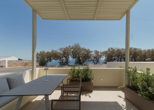 a patio with a table and chairs on a balcony at KYMA Suites Andros in Gavrion