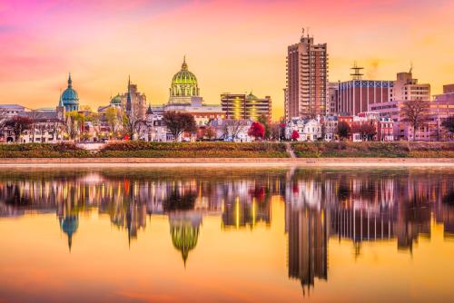 a city skyline with a reflection in the water at BurgBnB Downtown in Harrisburg