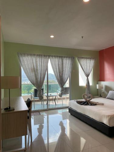 a bedroom with a large bed and a large window at Homestay Marina in Lumut