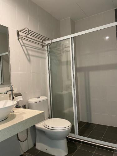 a bathroom with a shower and a toilet and a sink at Homestay Marina in Lumut