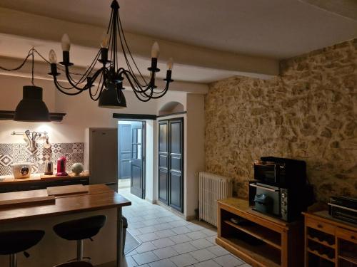 a kitchen with a chandelier hanging from the ceiling at Grand mas provençal 4 chambres, dortoir 7 pers, idéal familles groupes, fraîcheur d'été in Montfaucon