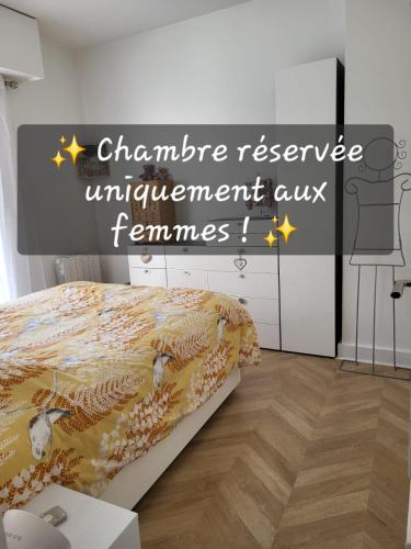 a bedroom with a bed with a sign that reads guarantee reserve unemployment only feminism at Une chambre au calme - Réservée aux femmes in Saint-Mandé