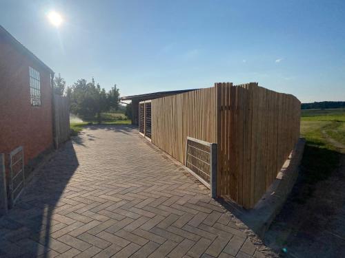 a wooden fence next to a brick walkway next to a building at Moderne Ferienwohnung mit Garten in Spalt