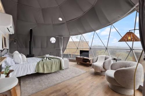 ein Schlafzimmer mit einem Bett und einem großen Fenster in der Unterkunft "Cardinal Crest" - The Overlook LUX Dome - RRG in Stanton