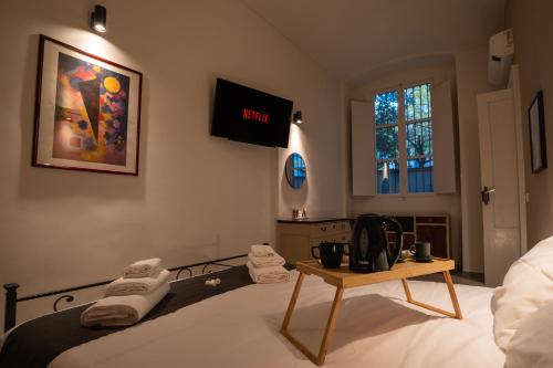 a bedroom with a bed with a tv on the wall at Metro18Dic - Stazione Porta Susa - Grazioso Bilocale in Turin
