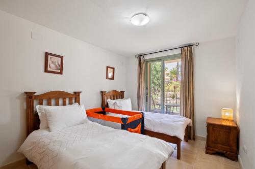 a bedroom with two beds and a window at Casa Lola Y Suki in Estepona