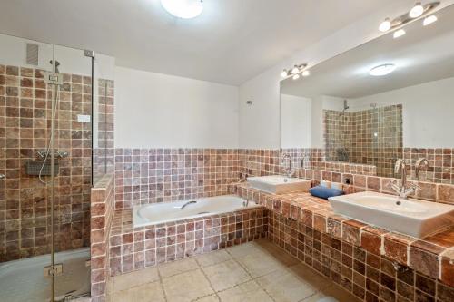 a bathroom with two sinks and two mirrors at Casa Lola Y Suki in Estepona