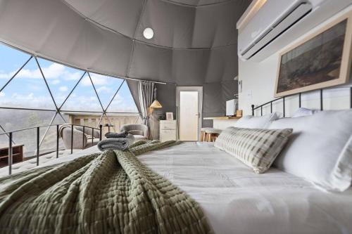 a bedroom with a large bed and a balcony at "Pineview Peak" The Overlook LUX Dome - RRG in Stanton