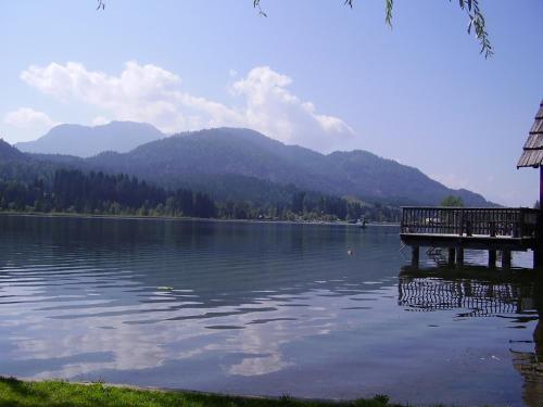 a lake with a dock and mountains in the background at Haus Garz in Weissensee