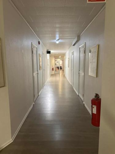 an empty hallway with doors and a fire extinguisher at Burning Bridge Motell & Vandrarhem in Götene