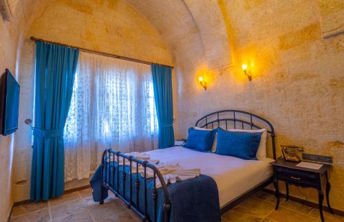 a bedroom with a bed and a window at Lagoon Cave Suites in Urgup