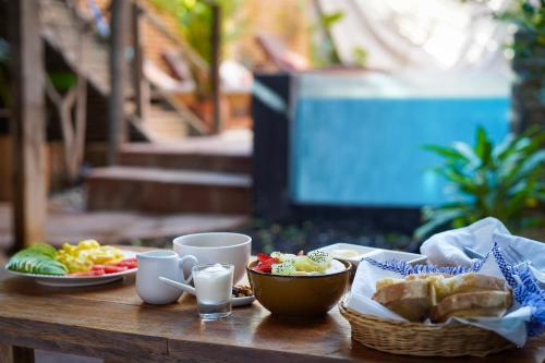 a table with plates of food and cups on it at Eco Lodge Mancora in Máncora