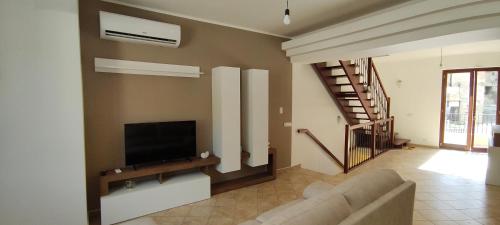 a living room with a couch and a flat screen tv at Tra mare e collina in Condrò