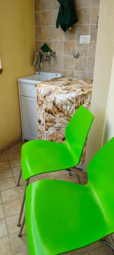 a green chair in a bathroom with a sink at Tra mare e collina in Condrò