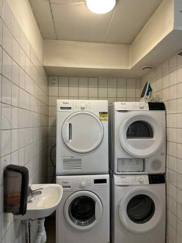 a bathroom with two washing machines and a sink at Burning Bridge Motell & Vandrarhem in Götene
