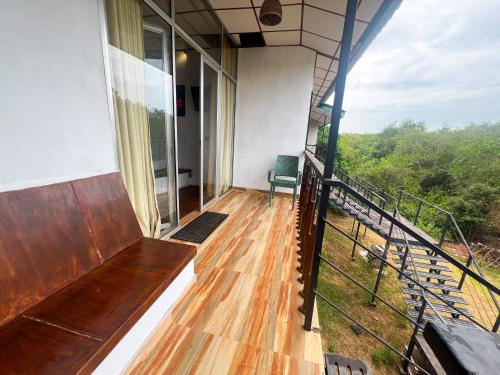 a balcony of a house with a bench on it at Wilpattu Nature Resort in Murandanveli