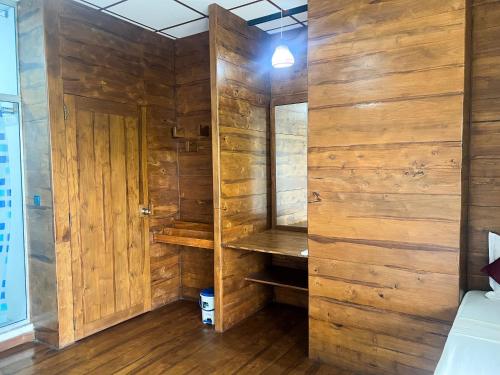 a room with wooden walls and a bed and a closet at Wilpattu Nature Resort in Murandanveli