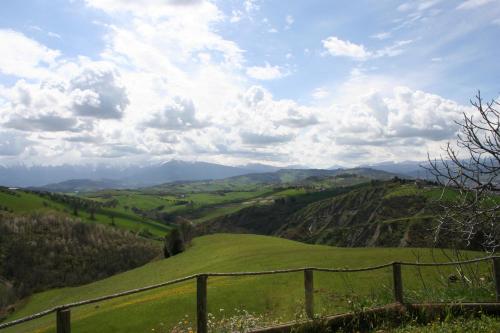 a view of a green hill with a fence at Casa Amrita B&B in Teramo