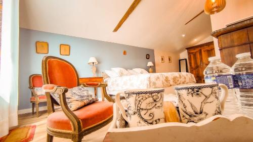 a bedroom with a bed and a chair at La Petite Lande in Ménil