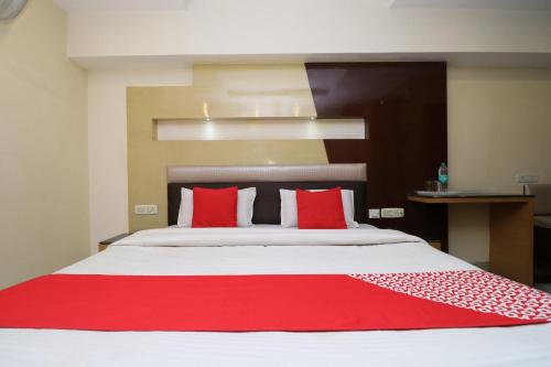 a bedroom with a large bed with red pillows at HOTEL O Vivek International Hotel in Jalandhar