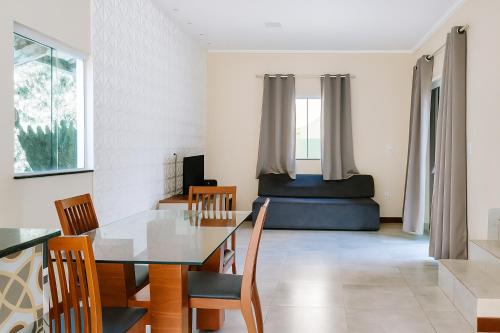a dining room with a table and chairs and a bed at Casa em Jauá in Camaçari