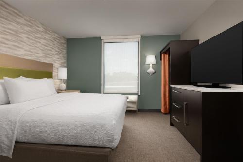 a bedroom with a bed and a flat screen tv at Home2 Suites by Hilton Huntsville Research Park Area, AL in Huntsville