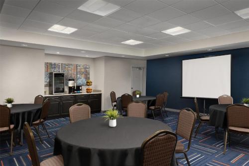 a conference room with tables and a white screen at Home2 Suites by Hilton Huntsville Research Park Area, AL in Huntsville