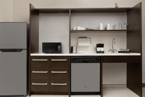 a kitchen with a refrigerator and a dishwasher at Home2 Suites by Hilton Huntsville Research Park Area, AL in Huntsville