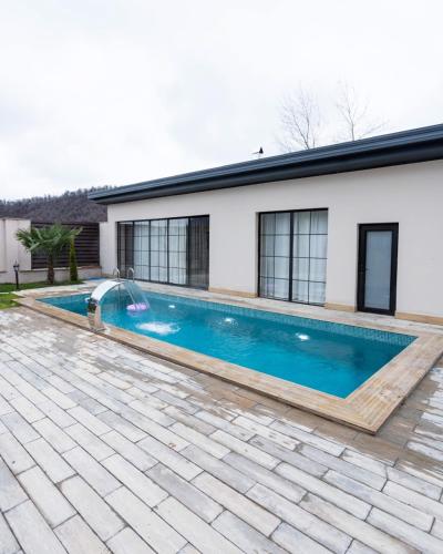 a swimming pool in front of a house at Veni Vidi Villas Gabala in Gabala