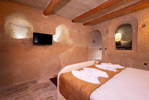 a bed in a room with two white pillows on it at Lagoon Cave Suites in Urgup