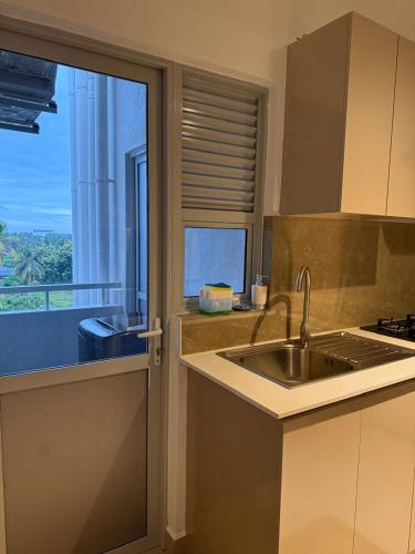 a kitchen with a sink and a window at Zeleny Santorini in Negombo